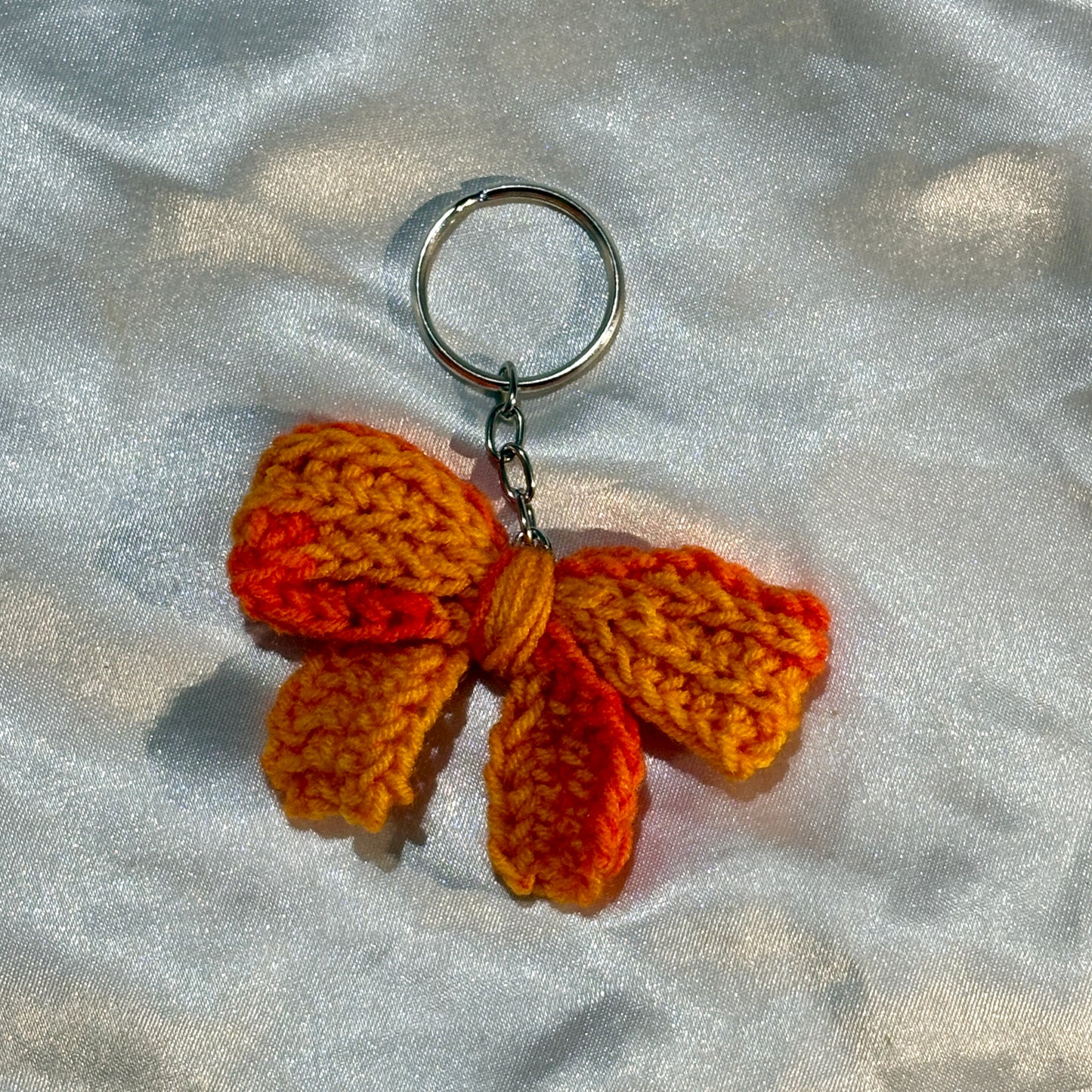 bow keychain on a silver satin background