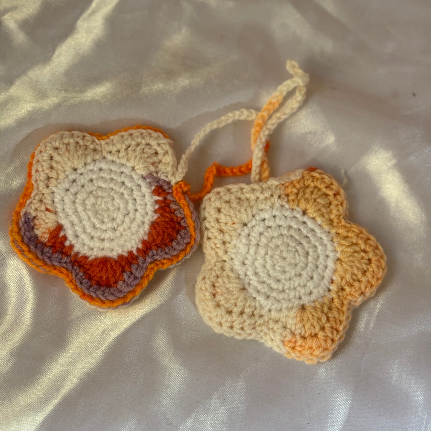 Two crocheted pouch with a gradient of colors on a textured surface.