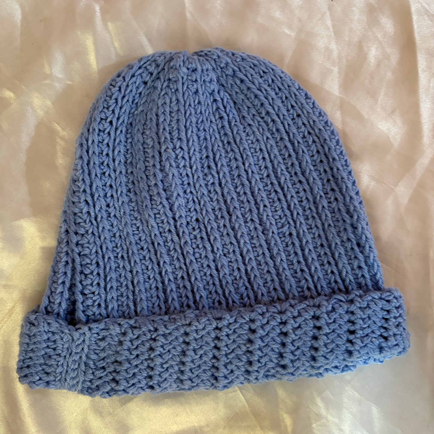 Blue crochet beanie on a light beige background