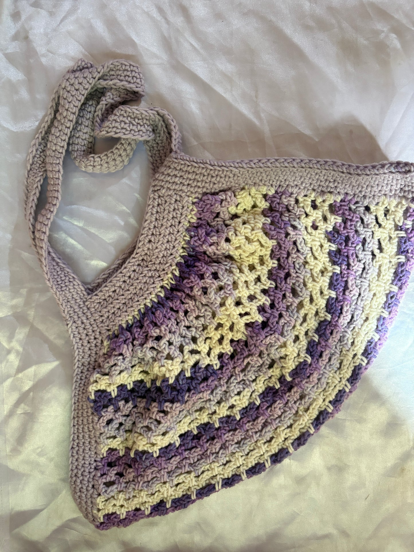 Crocheted bag with purple and white pattern on a white background