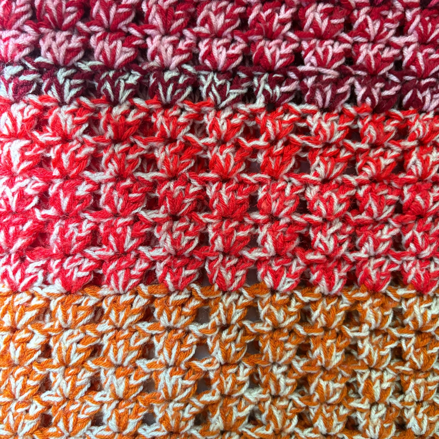 Close-up of a textured fabric with red, white, and orange pattern