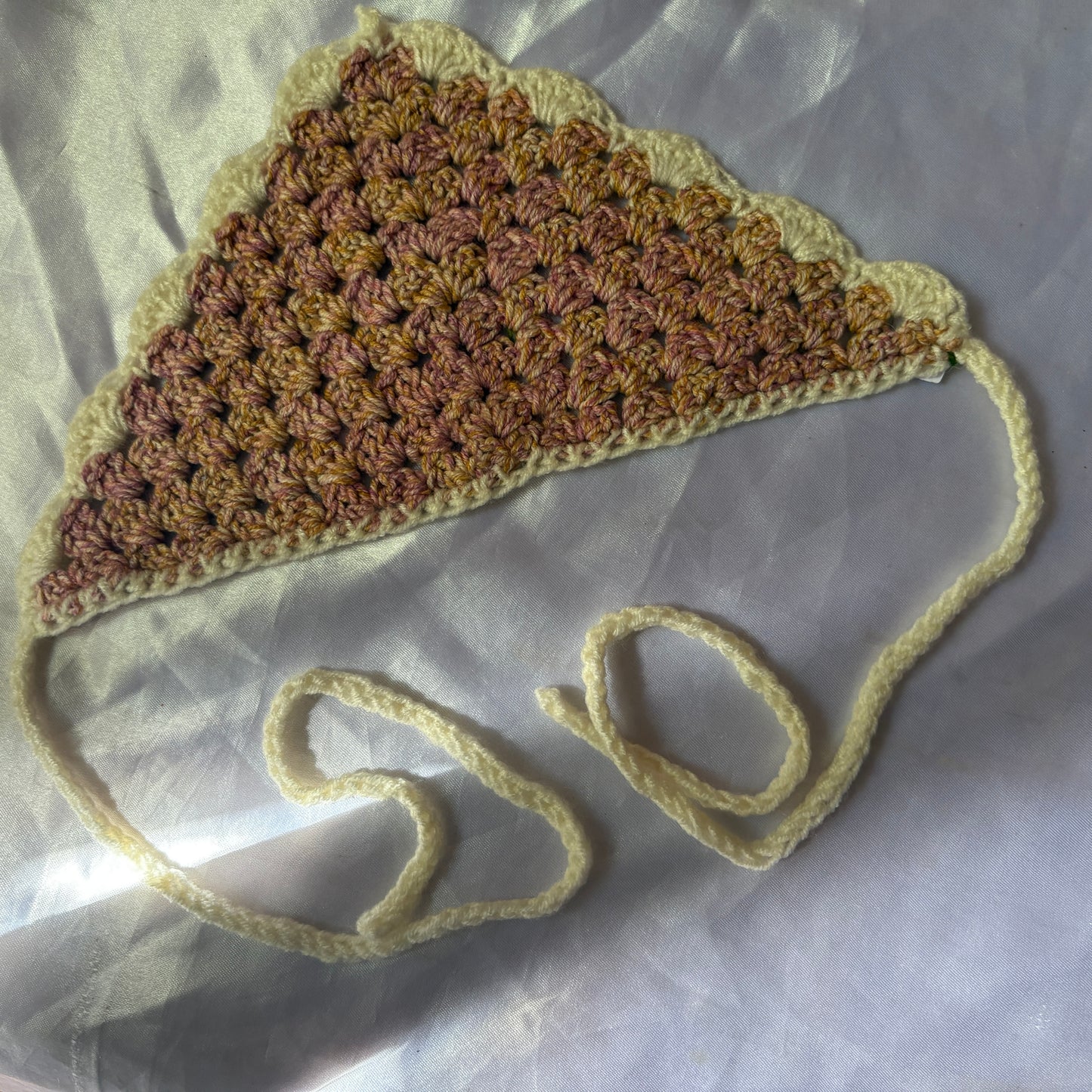Crocheted bandana with a strap on a light background