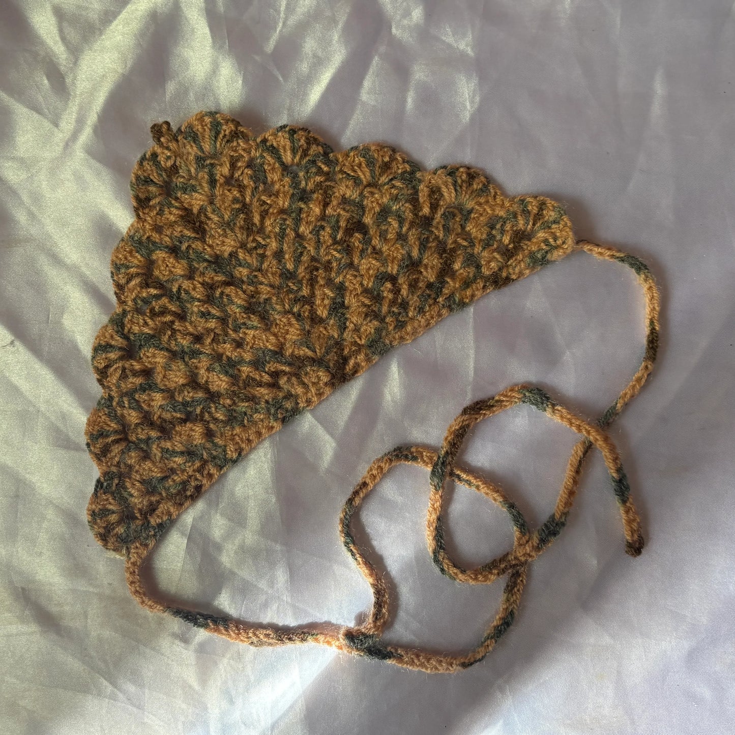 Crocheted bandana with a strap on a light background