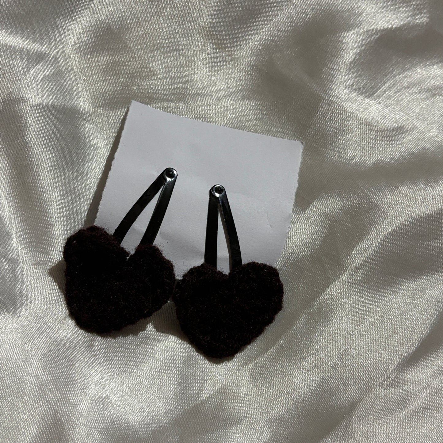 Black clips on a white card with a textured gray background