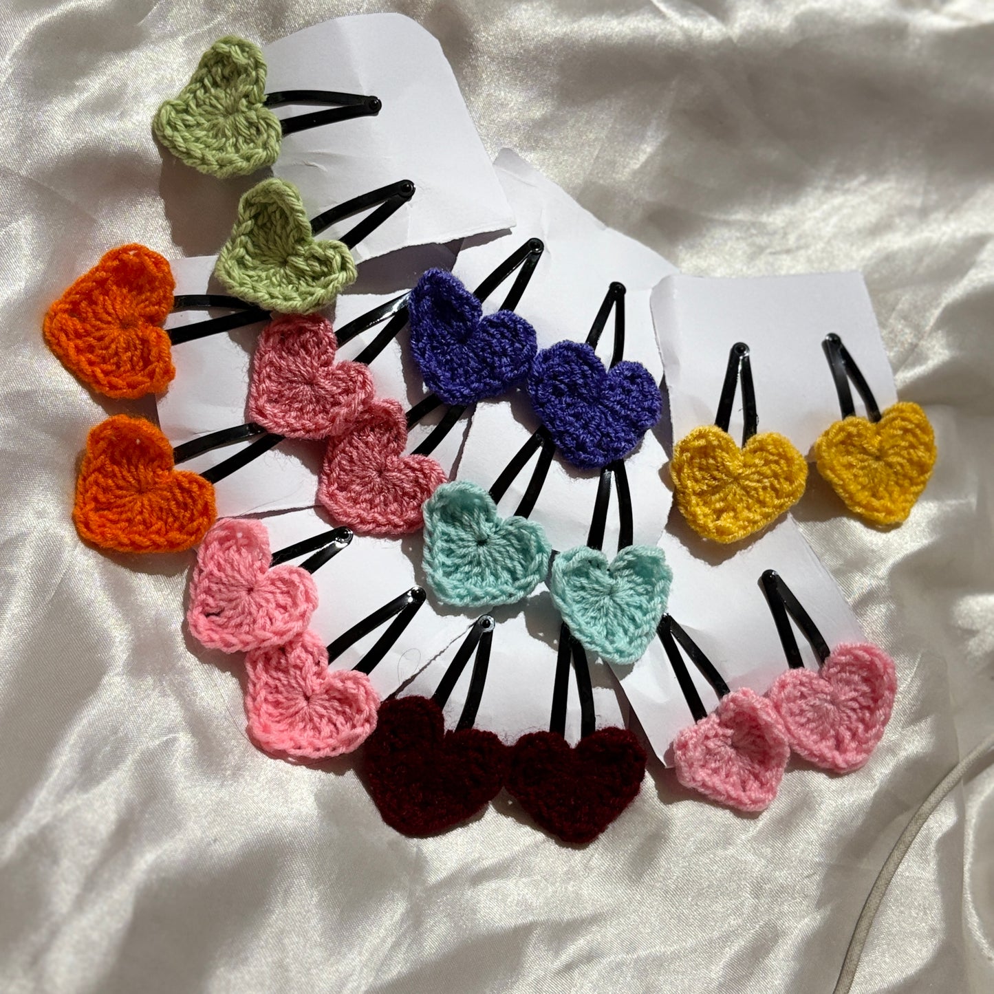 Colorful heart-shaped hair clips on a white background