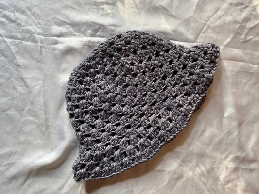Gray crocheted hat on a white fabric background