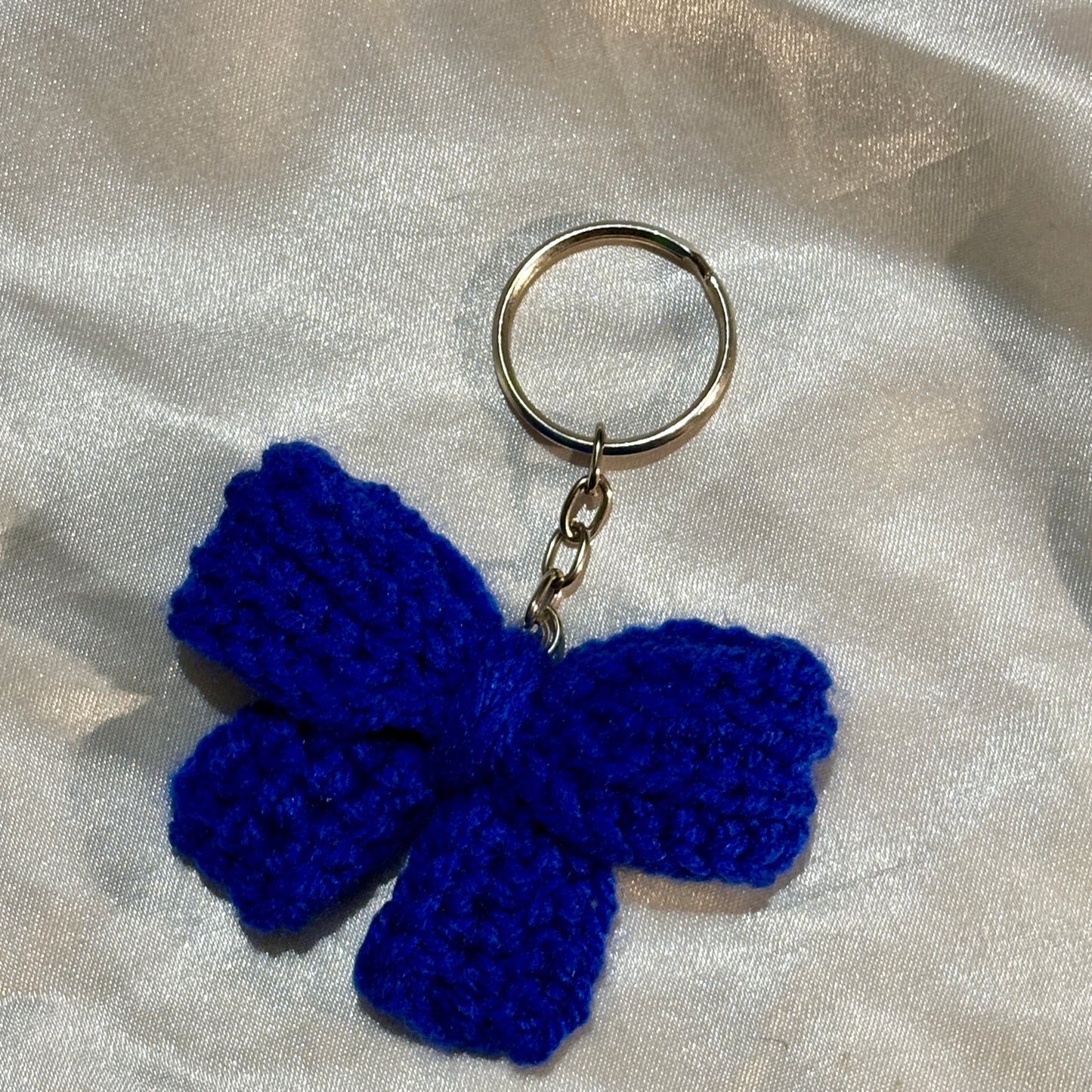Blue bow keychain on a silver satin background
