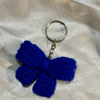 Blue bow keychain on a silver satin background