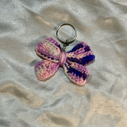 Purple bow keychain on a silver satin background