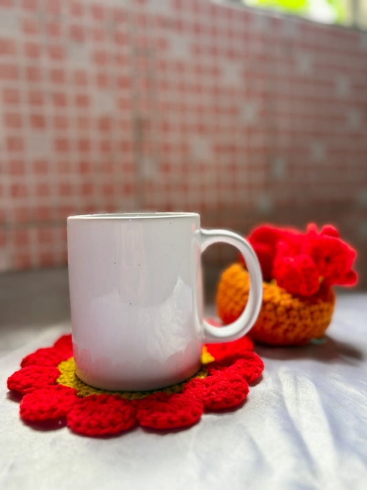 White mug on a red floral coaster with a blurred checkered wall in the background