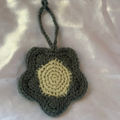 Crocheted heart-shaped pouch with a yellow center on a light pink background