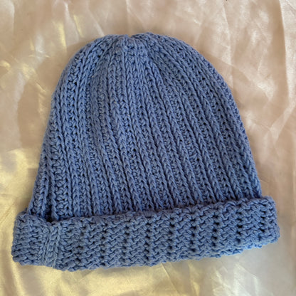 Blue crochet beanie on a light beige background