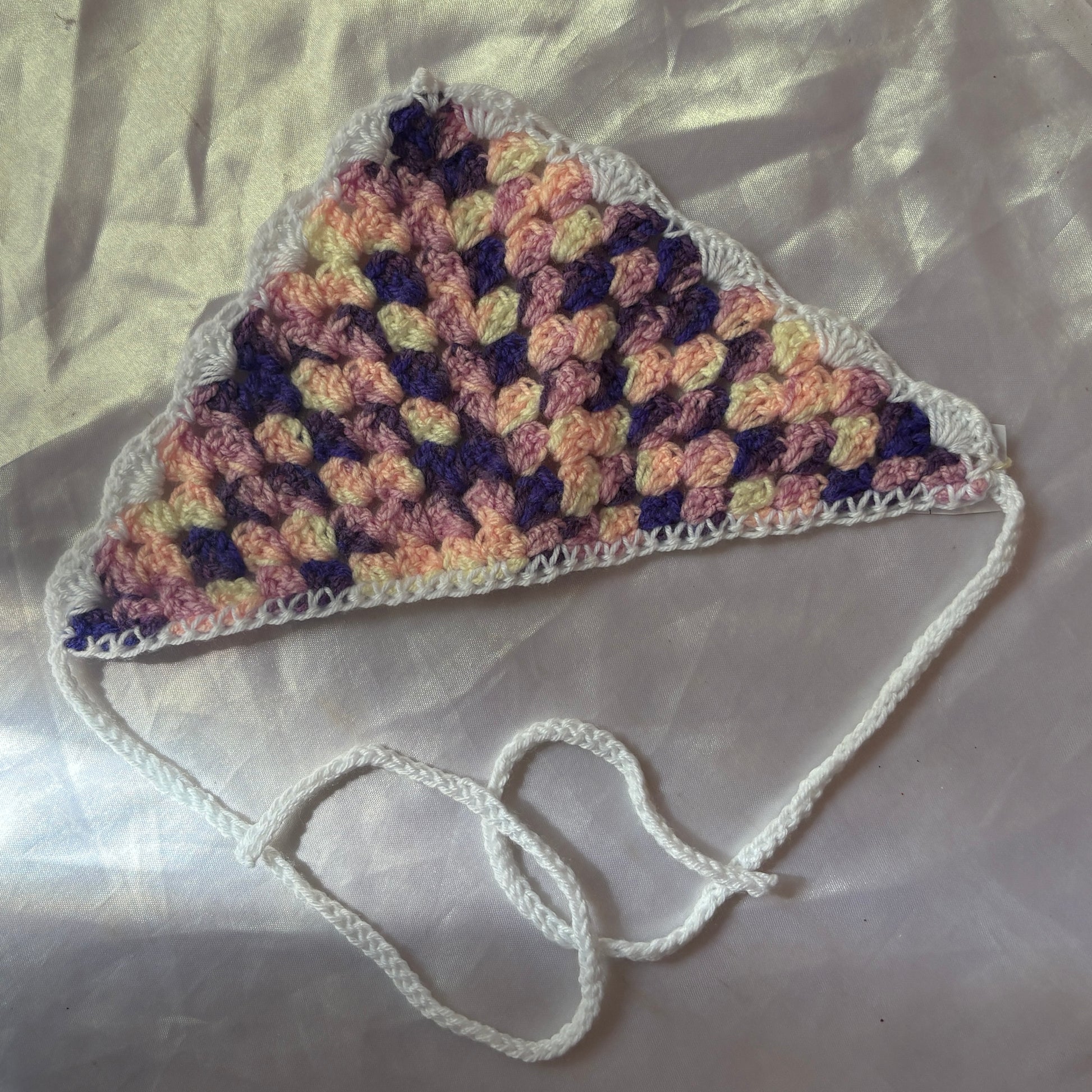 Crocheted bandana with a strap on a light background
