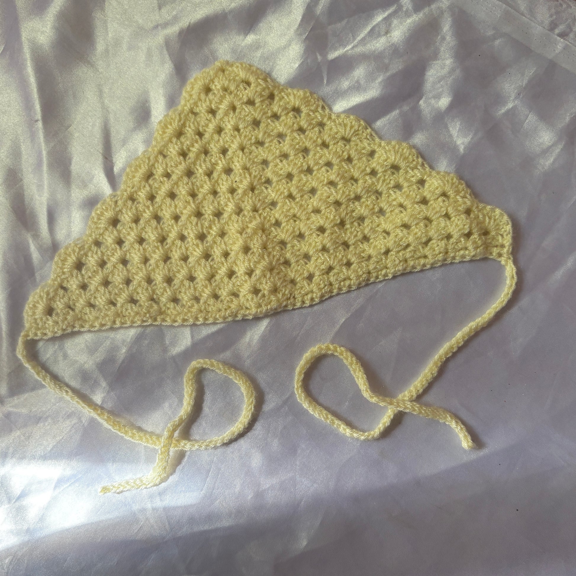 Crocheted bandana with a strap on a light background