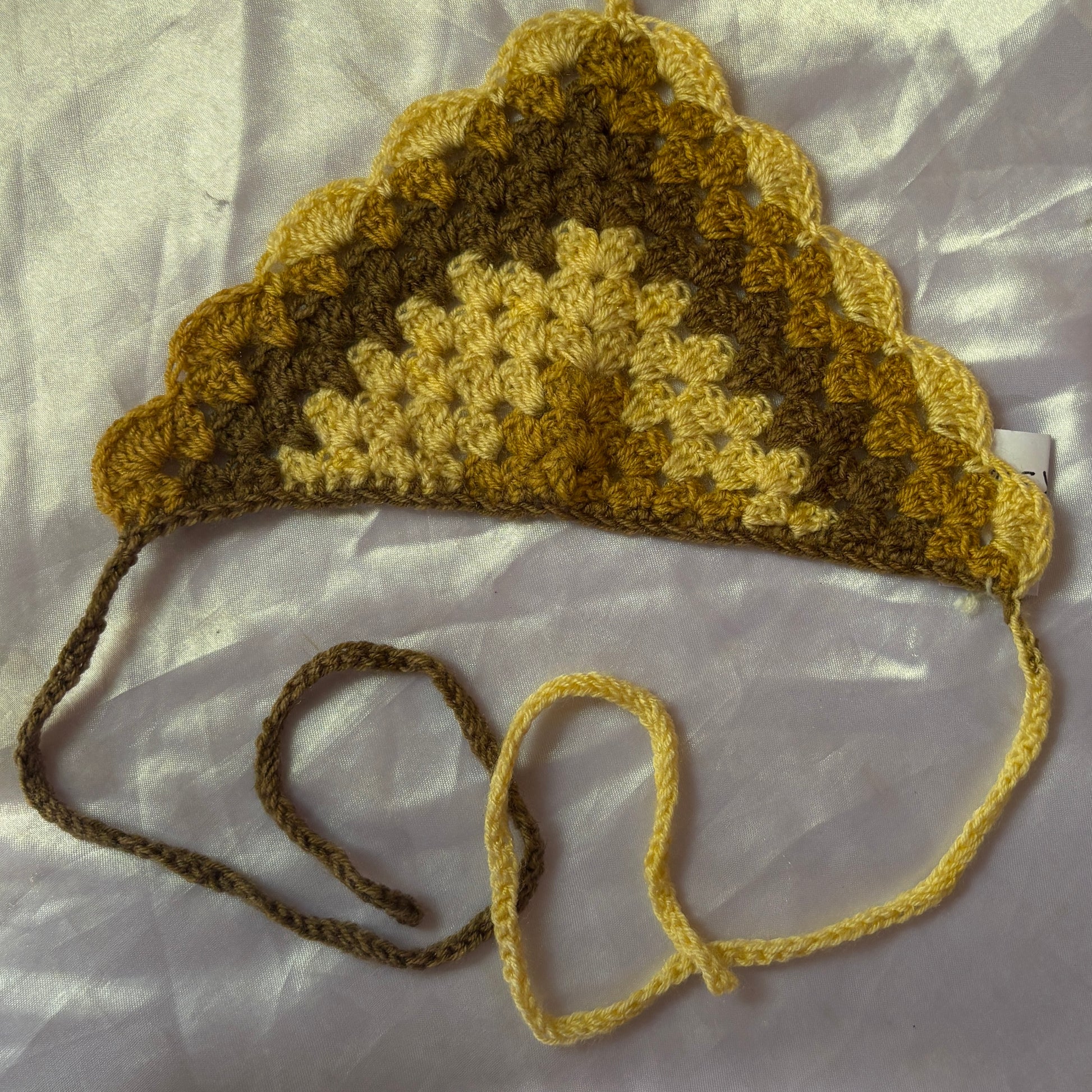 Crocheted bandana with a strap on a light background