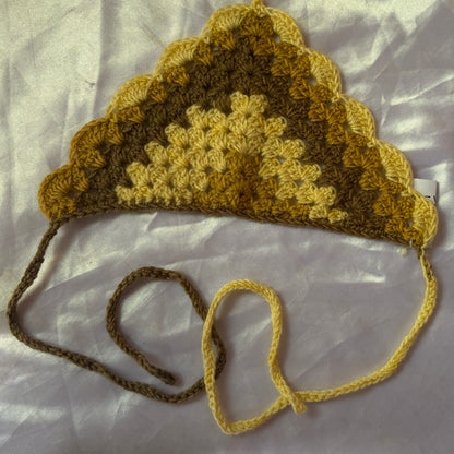 Crocheted bandana with a strap on a light background