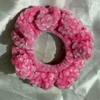 Pink textured scrunchie on a light fabric background