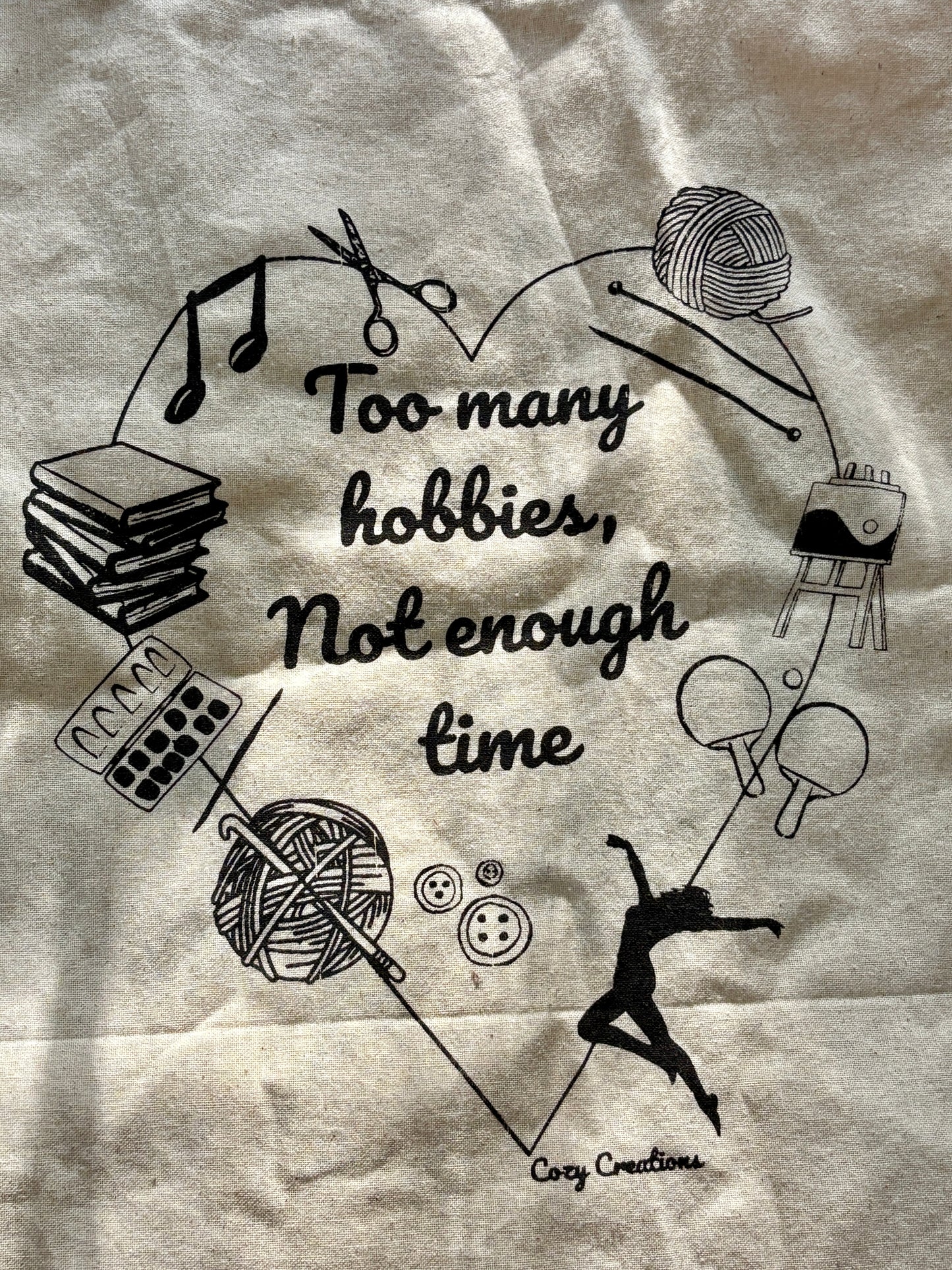 Illustration of various hobbies with text 'Too many hobbies, not enough time' on a textured background. - on a tote bag