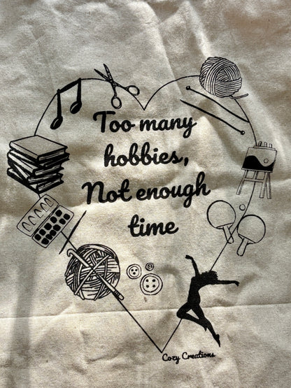 Illustration of various hobbies with text 'Too many hobbies, not enough time' on a textured background. - on a tote bag
