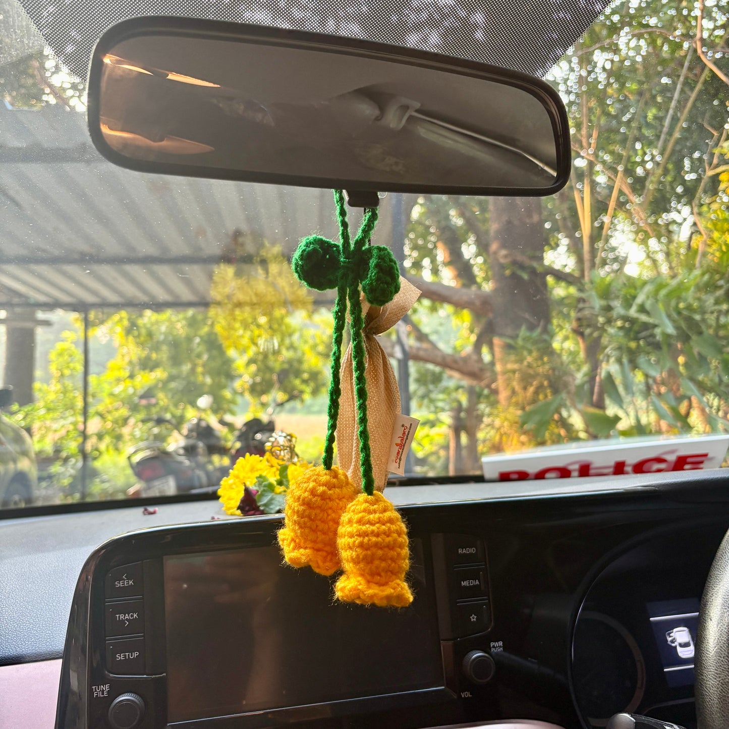 Crocheted flower decoration hanging from a car's rearview mirror