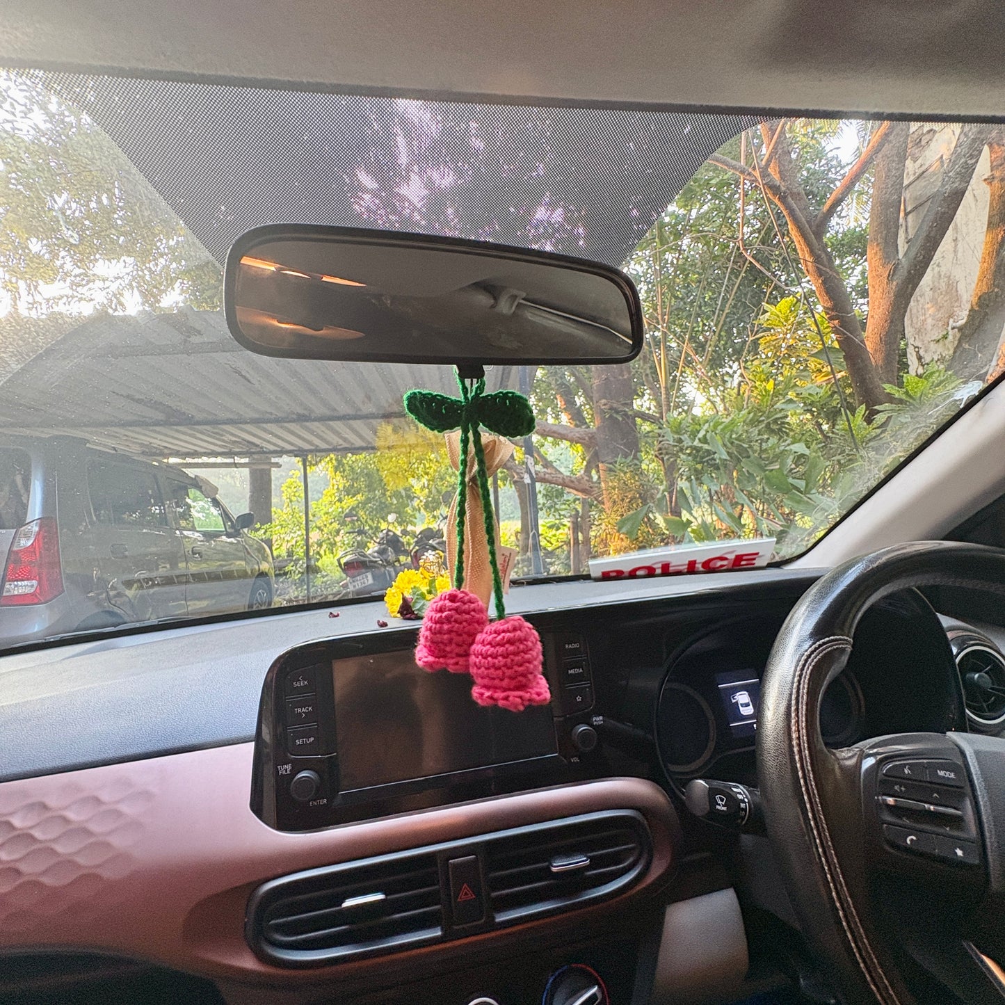 Crocheted flower decoration hanging from a car's rearview mirror