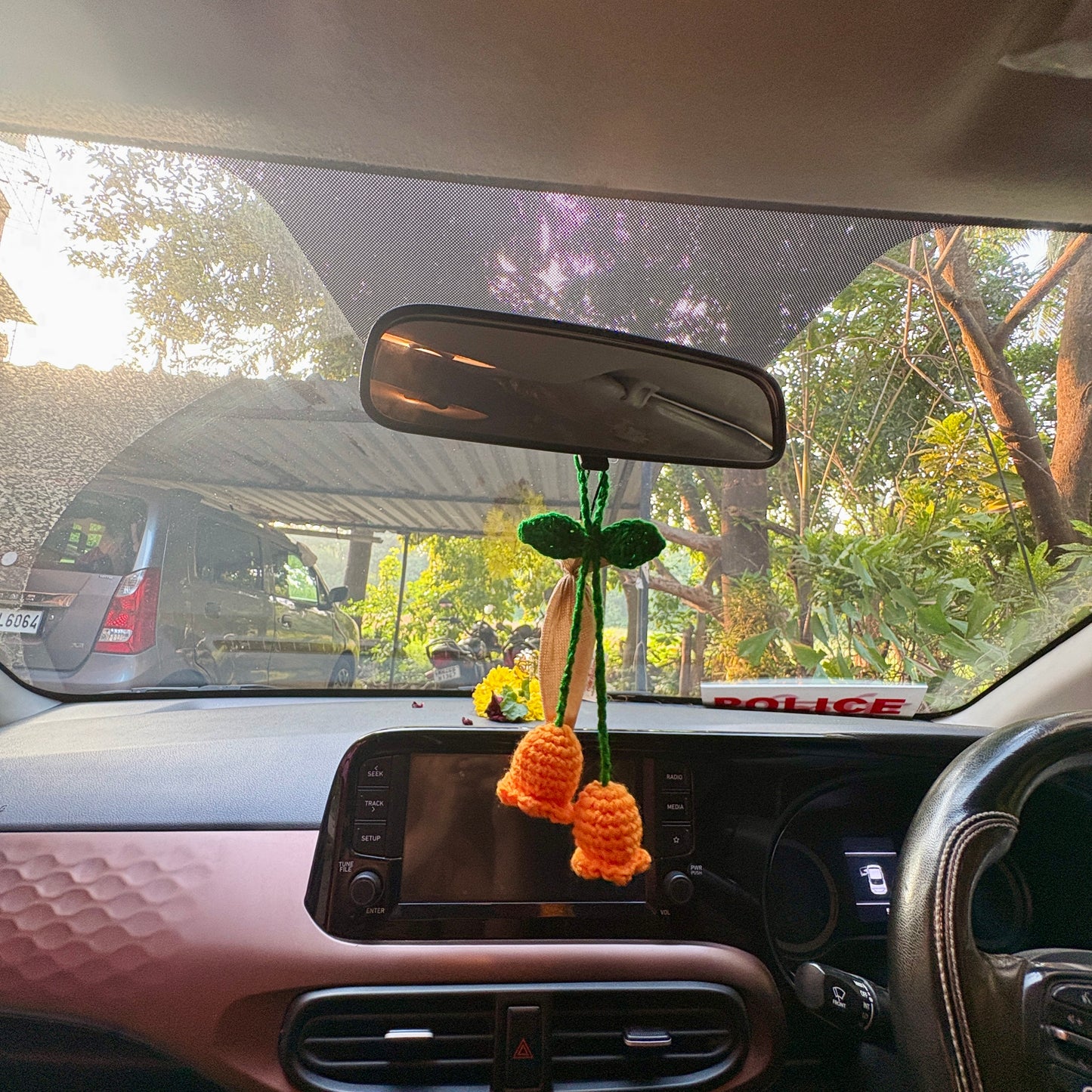 Crocheted flower decoration hanging from a car's rearview mirror