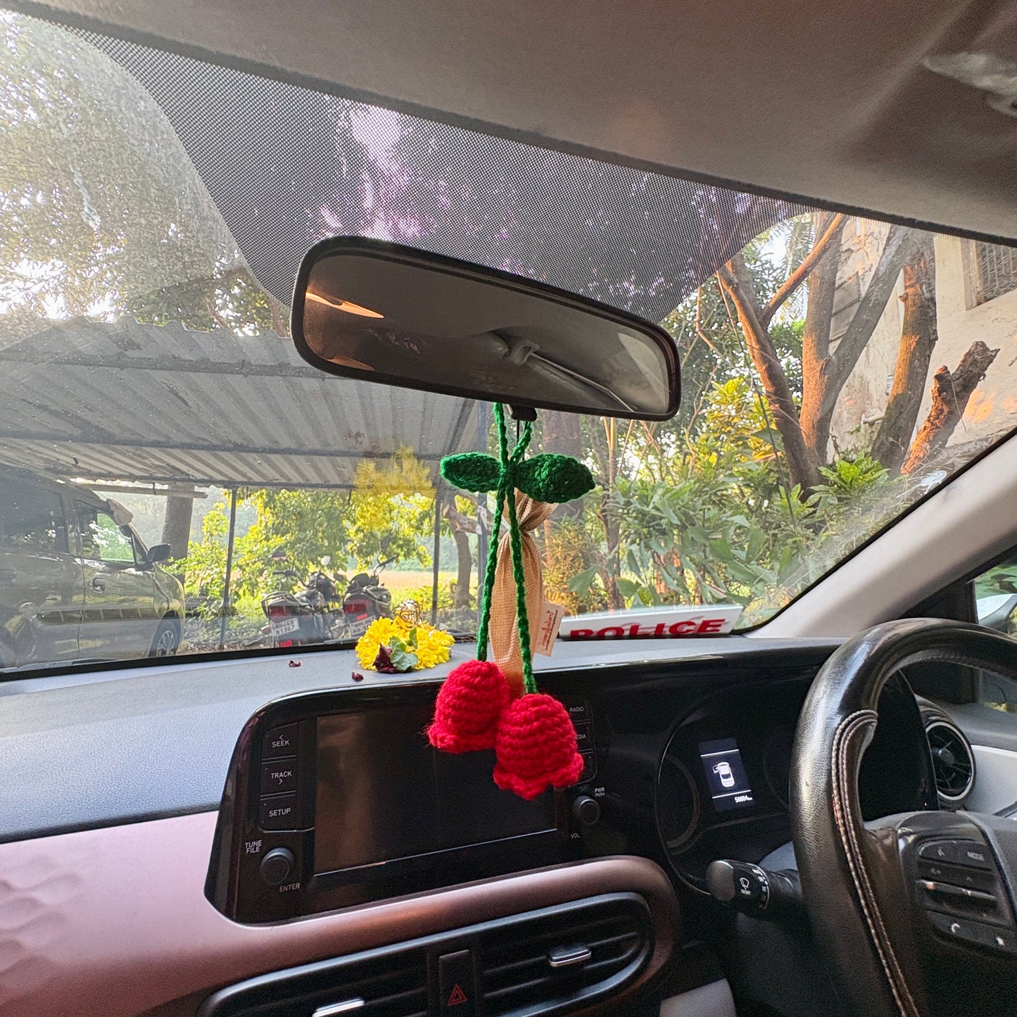Crocheted flower decoration hanging from a car's rearview mirror