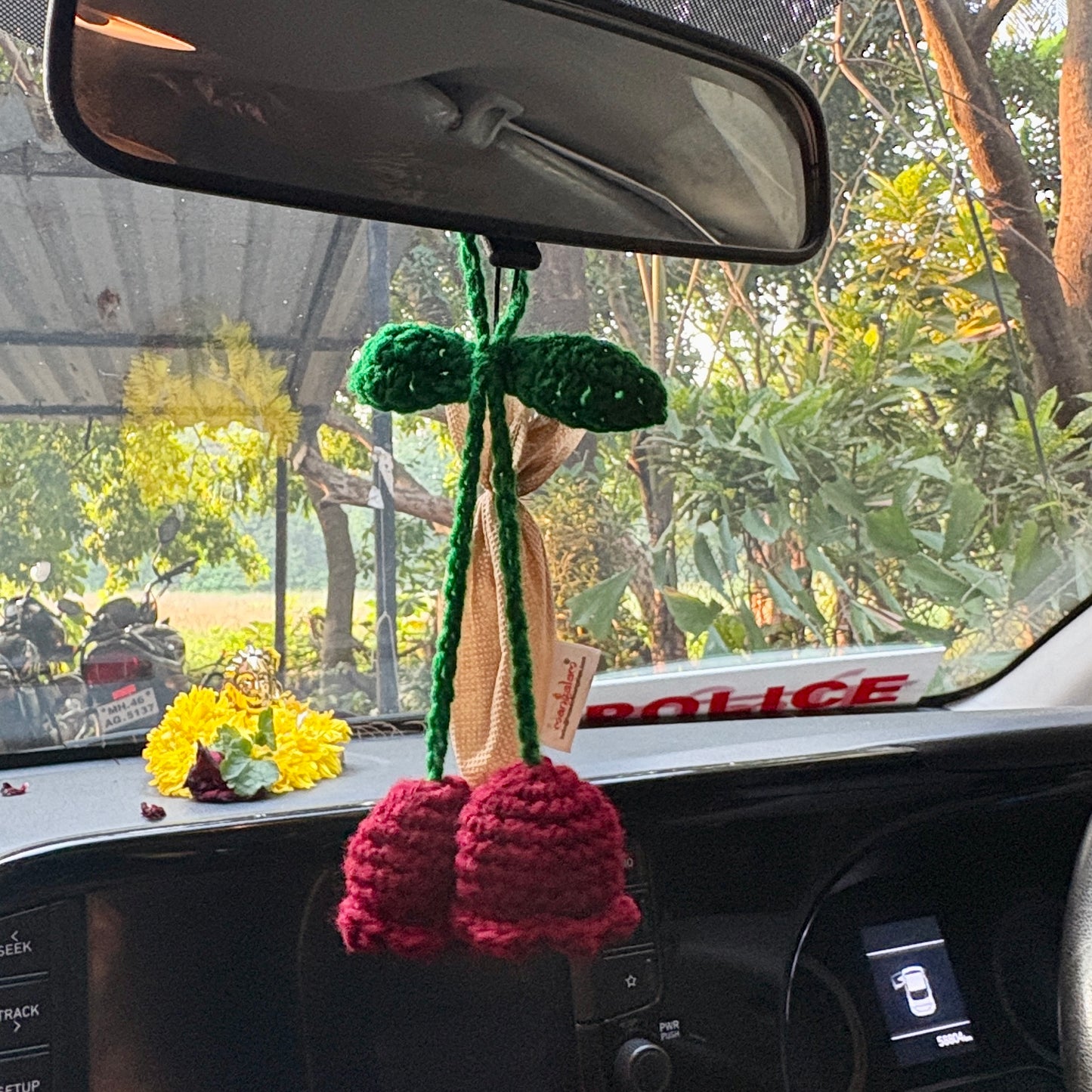 Crocheted flower decoration hanging from a car's rearview mirror