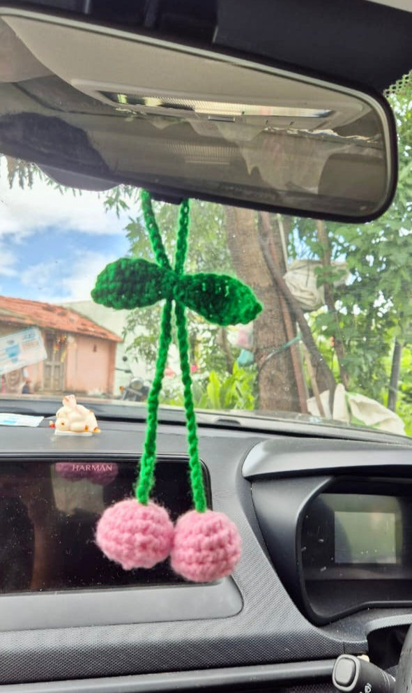 Car interior with a decorative item hanging from the rearview mirror