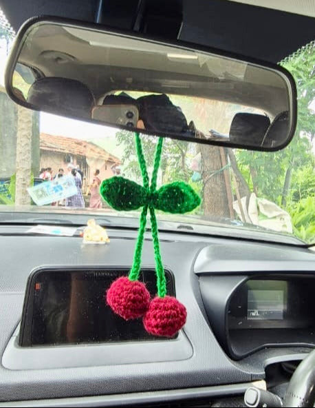 Car interior with a decorative item hanging from the rearview mirror.